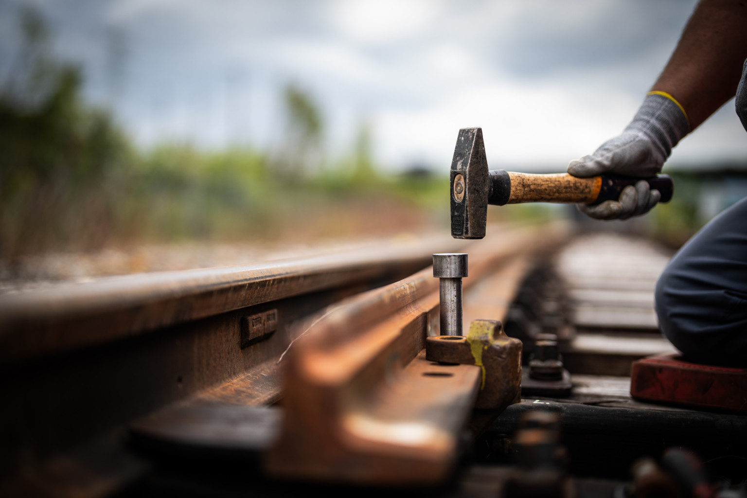 An einer Gleise wir ein Kolben mit einem Hammer reingehauen.