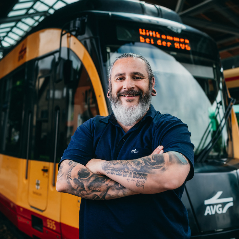 Marcus Grün steht mit verschränkten Armen vor einer S-Bahn 